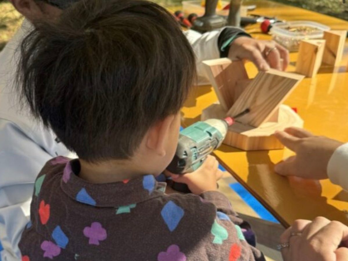 電動ドライバーで木を組み立てる子ども