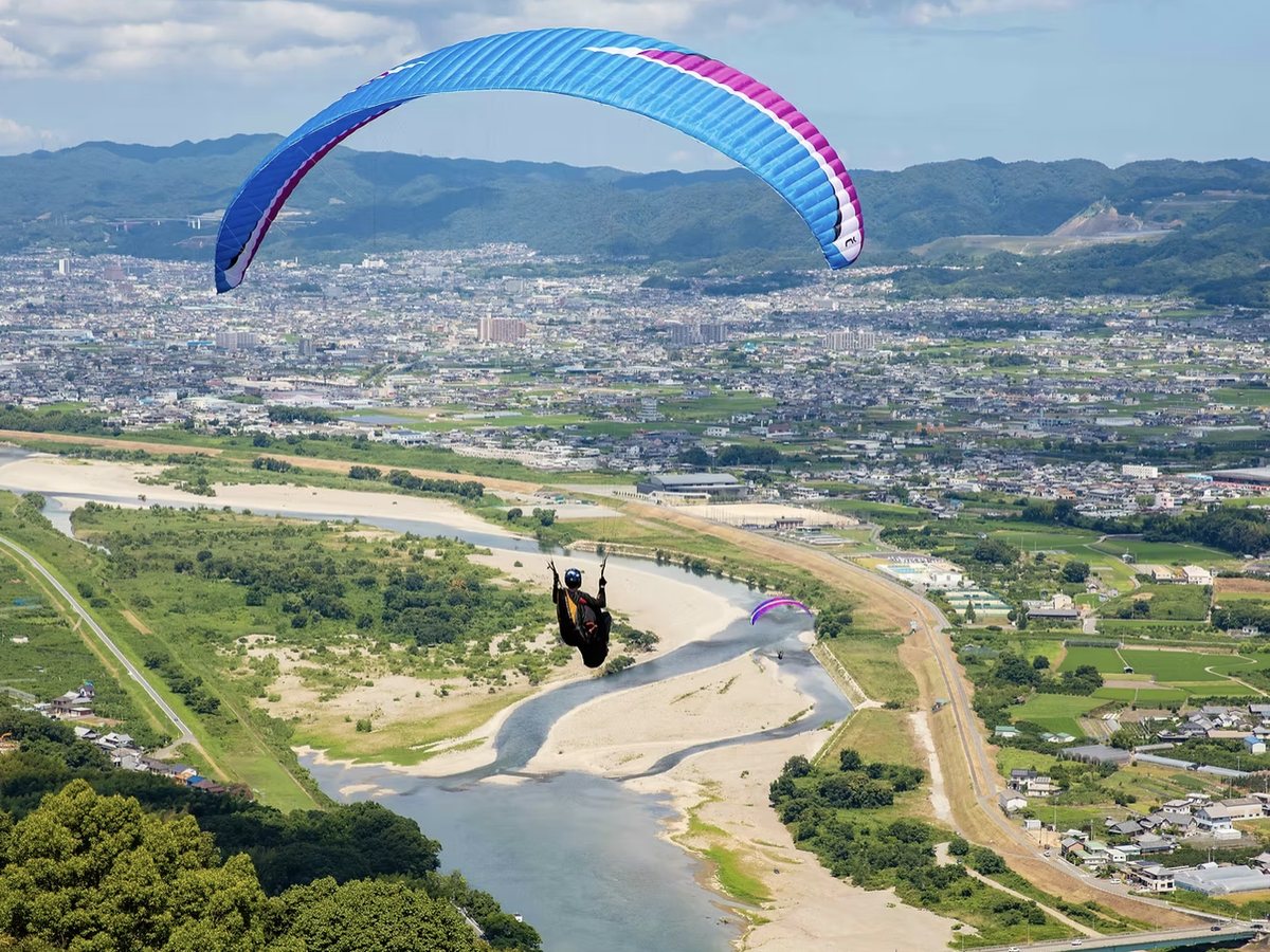 紀の川の上空を飛ぶパラグライダー